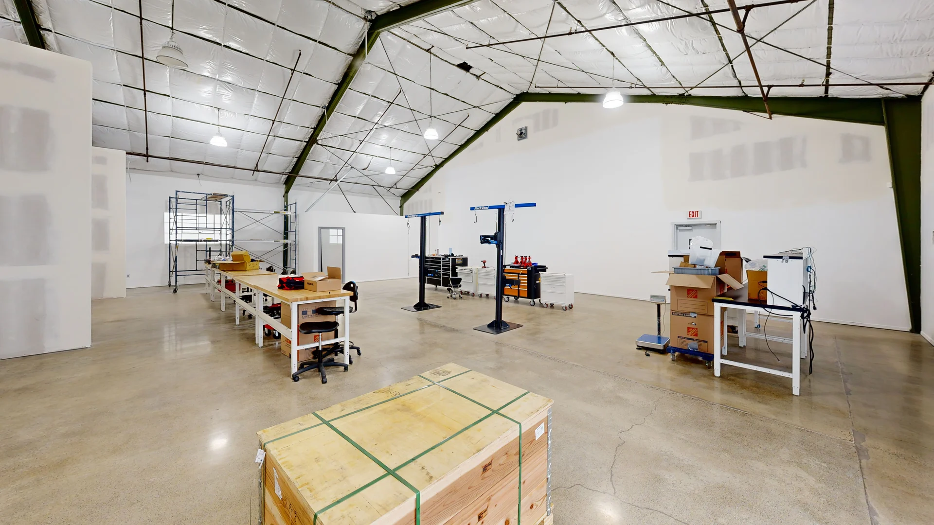 High-ceiling commercial workshop with exposed structure and workstations